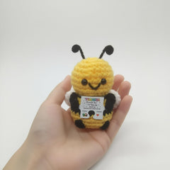 Compact bee plush about 2-3 inches tall with wooden stand