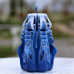 Blue carved candle with navy stripes and purple accents