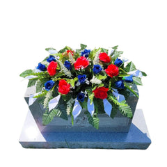 Cemetery Saddle Memorial Decoration with red white blue silk flowers on headstone