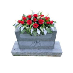 Cemetery Saddle Memorial Decoration with red roses and white calla lilies on headstone