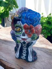 Left ear and hair feature colorful floral accents on the Talavera planter