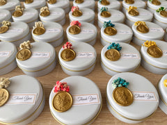 Dried flowers embellish candle favors in sealed tin box