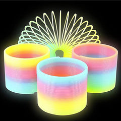Glow-in-The-Dark Rainbow Slingy coil spring toy glowing in low light