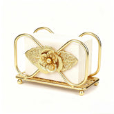 Gold napkin holder on table with floral pattern