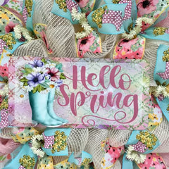 Decorative wreath featuring rain boots filled with flowers and deco mesh