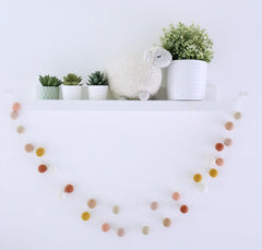 Close up of blush apricot tones on felt balls garland