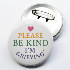 Close-up of 2.3 inch diameter grief pin text PLEASE BE KIND I'M GRIEVING