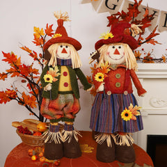 Male scarecrow with green overall and sunflower hat