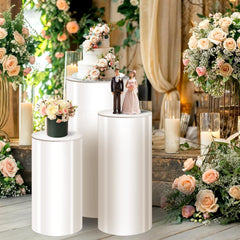 Three white cylinder pedestal stands in sizes 35.4 29.5 23.6 inches for party displays