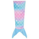Kid wearing blue colorful mermaid tail blanket on sofa