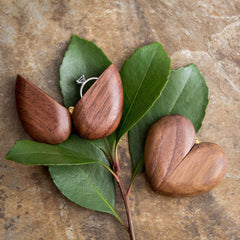Walnut wood engagement ring box opens from the tip with velvet foam