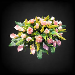 Peach roses and white calla lilies in cemetery saddle