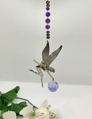 Pewter fairy centerpiece with amethyst gemstones in a sun catcher window