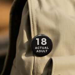 58mm pin back badge in black background with white text