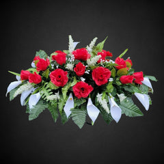 Silk faux floral grave flowers featuring red roses and white calla lilies
