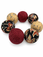 Three dark gray balls with burgundy and beige designs