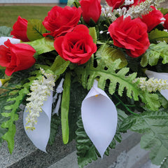 Metal saddle frame with four legs supporting grave flowers