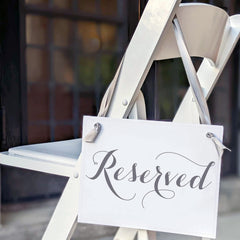 Two reserved chair signs with gray satin ribbon and slate gray text
