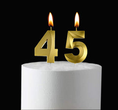 Gold 45th birthday candle pair on cake
