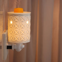 Plug in wax warmer shown glowing as night light