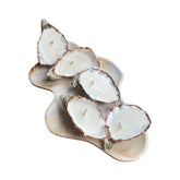 Gold edition oyster shell candle on a natural shell