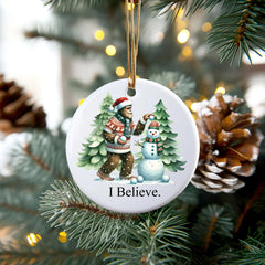 Sasquatch in a festive sweater with snowman ornament among pine trees