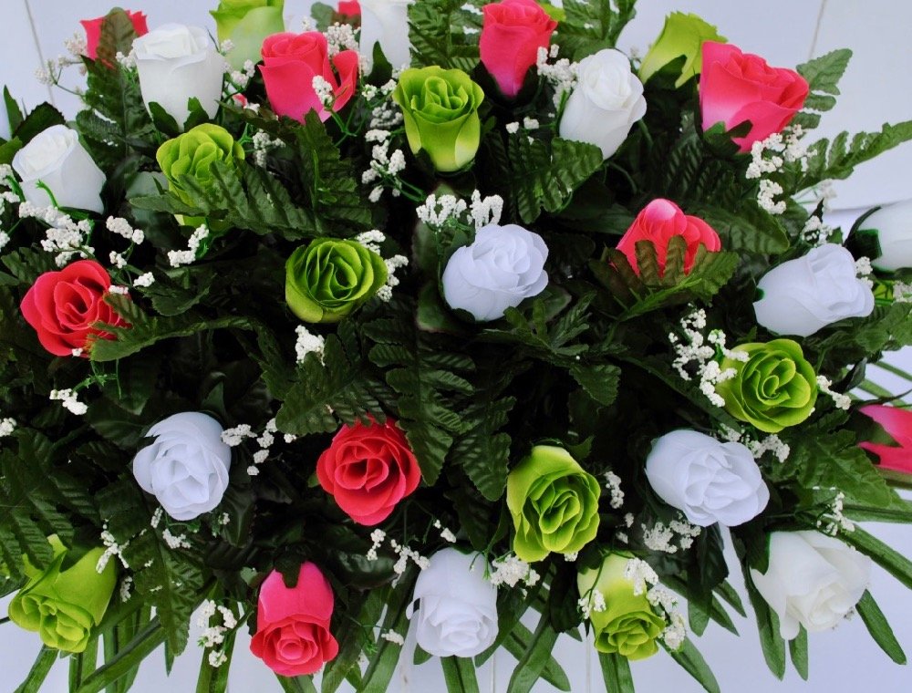 Vibrant silk roses with lush greenery for grave decoration