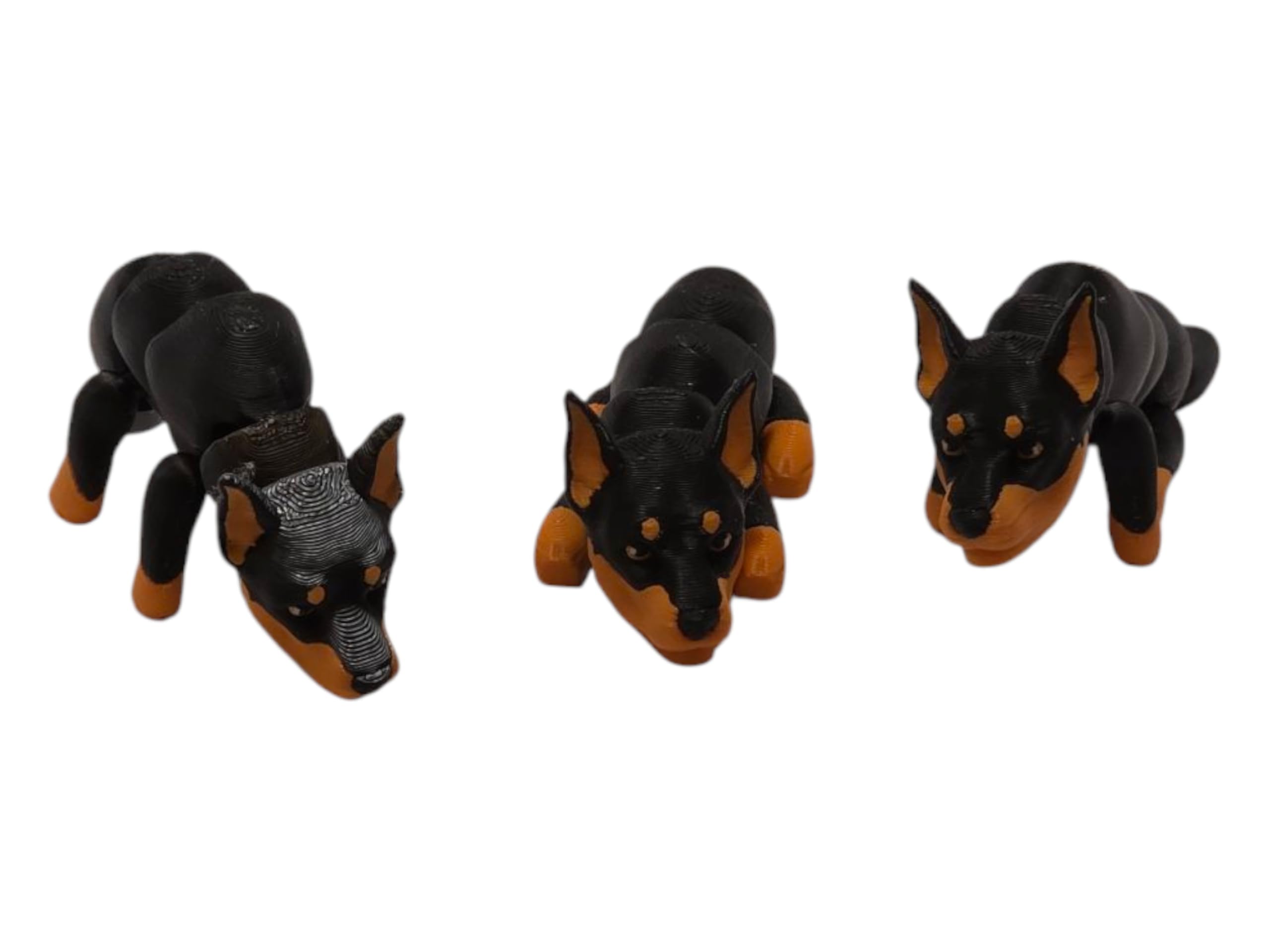 Three poseable Baby Doberman Figurines displayed on a shelf