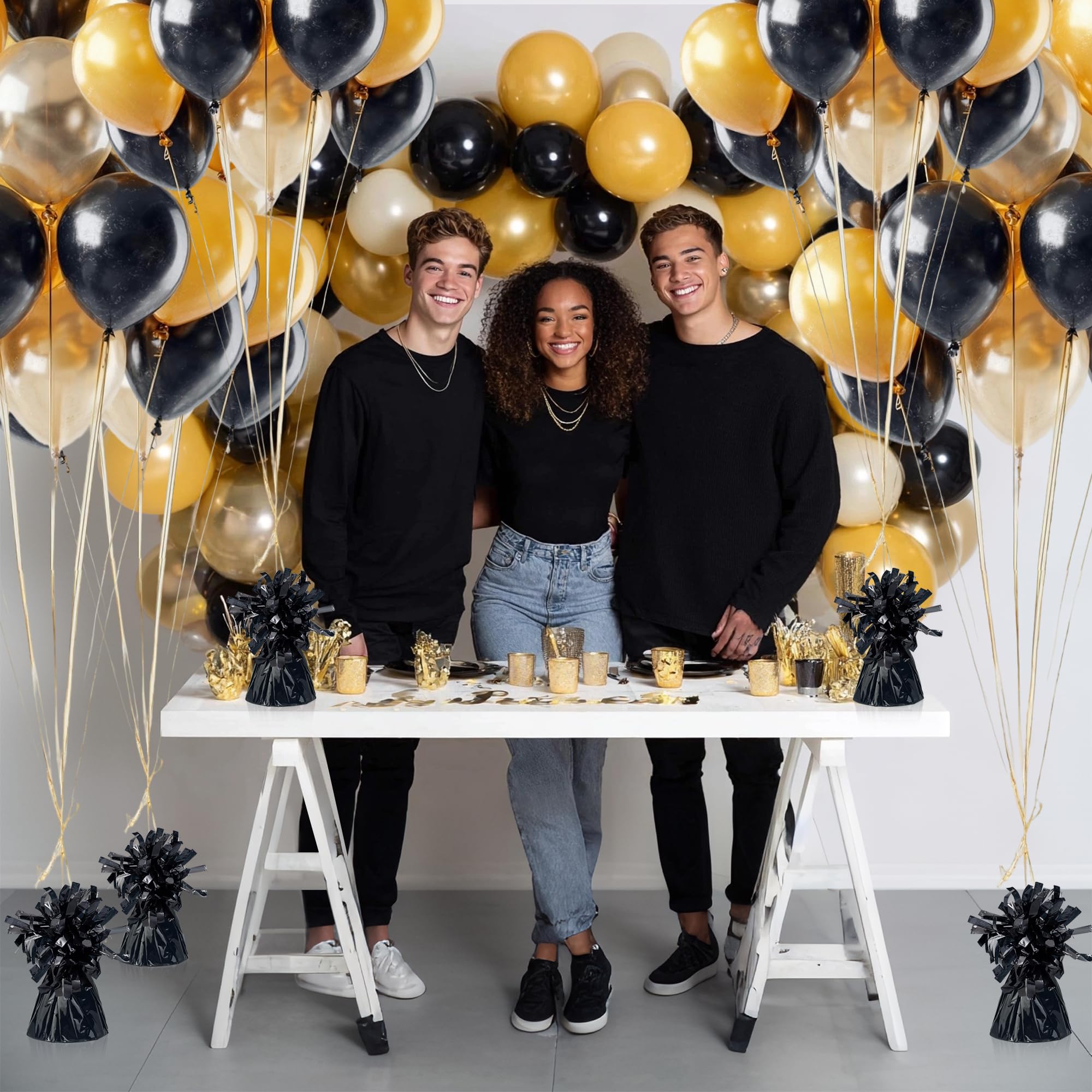 Party display with black balloon weights anchoring balloons