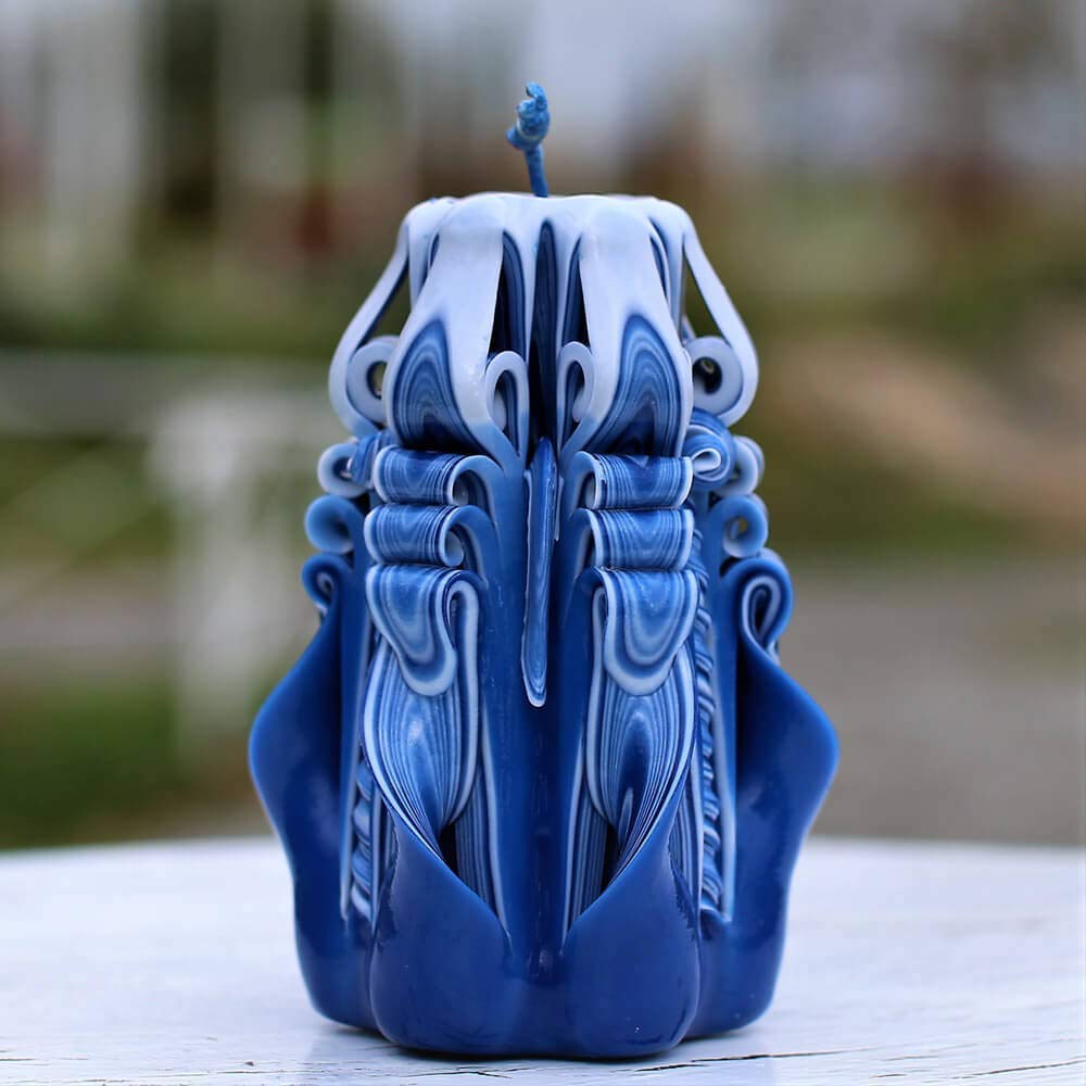 Blue carved candle with navy stripes and purple accents