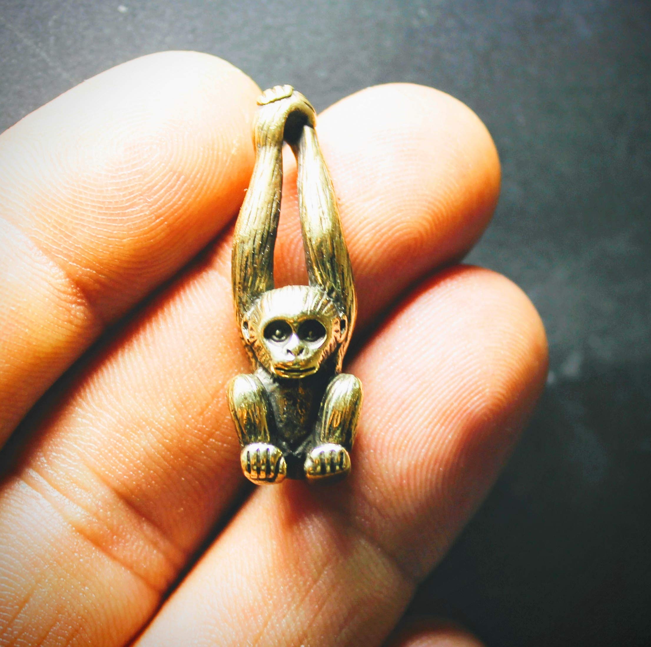 Brass monkey figurine keychain accessory on desk