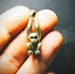 Brass monkey figurine keychain accessory on desk