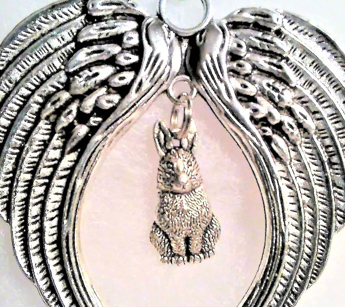 Antiqued metal angel wings ornament with satin cord hanging display