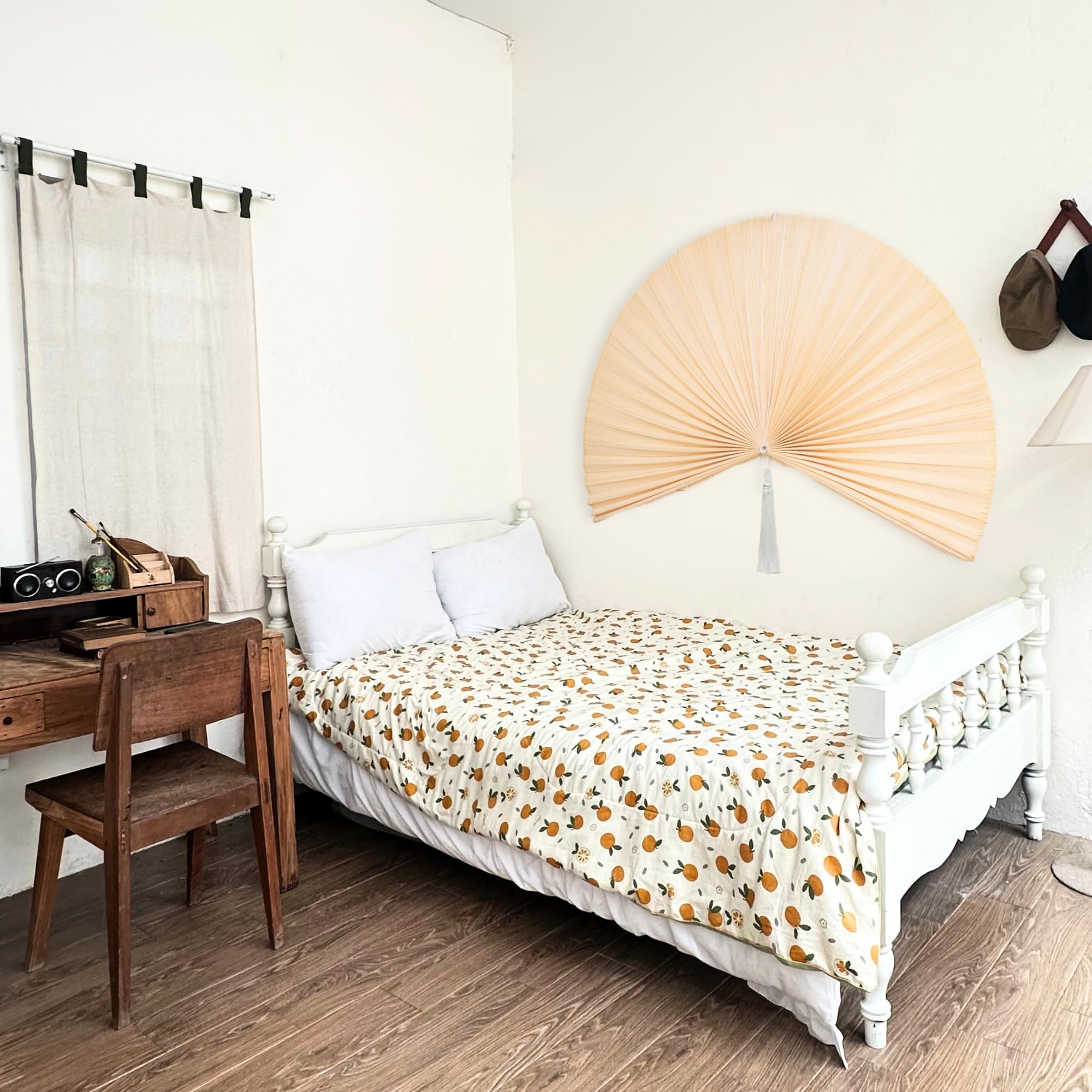 Decorative folding bamboo wall fan over bed