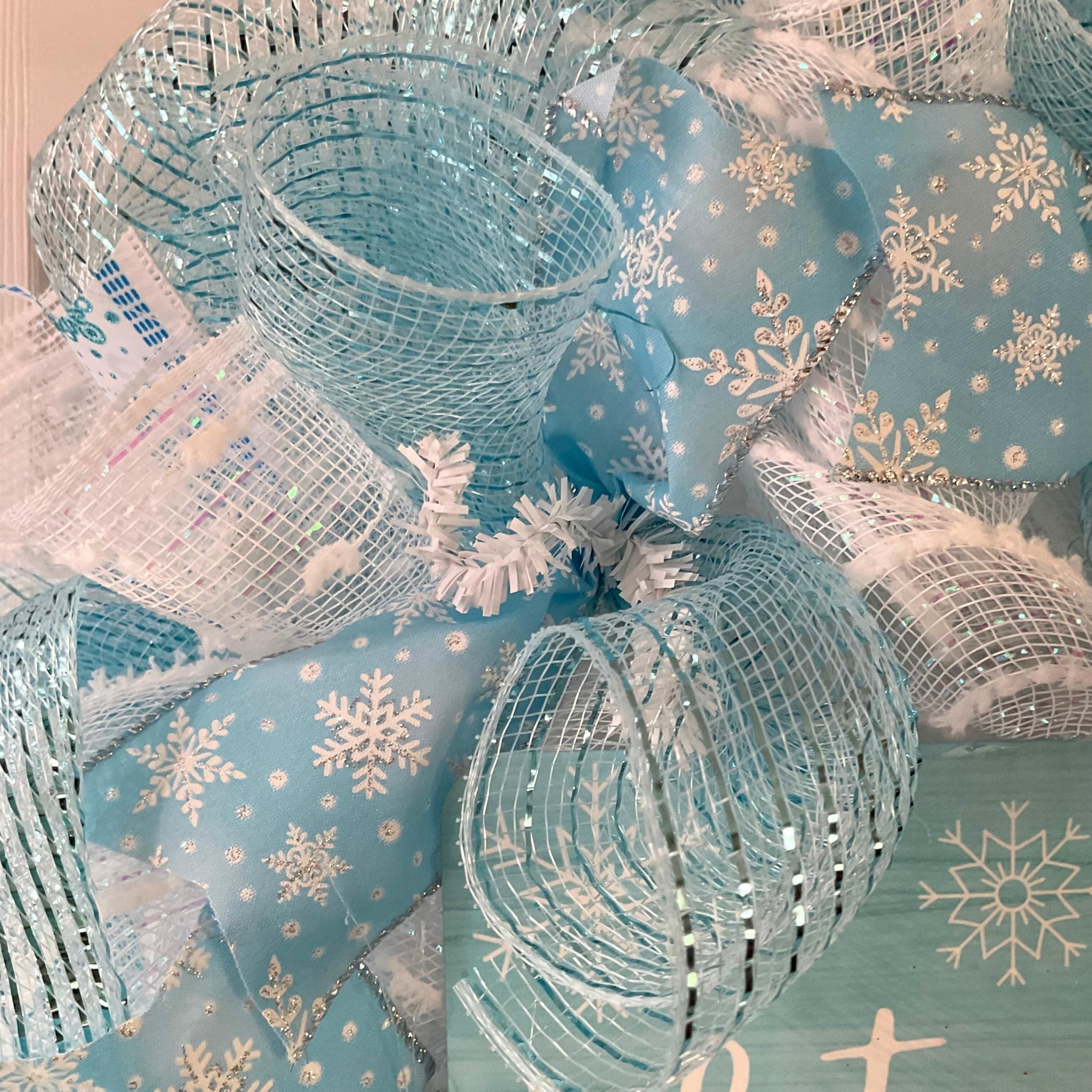Snowflake ribbons on a white blue wreath decorative sign