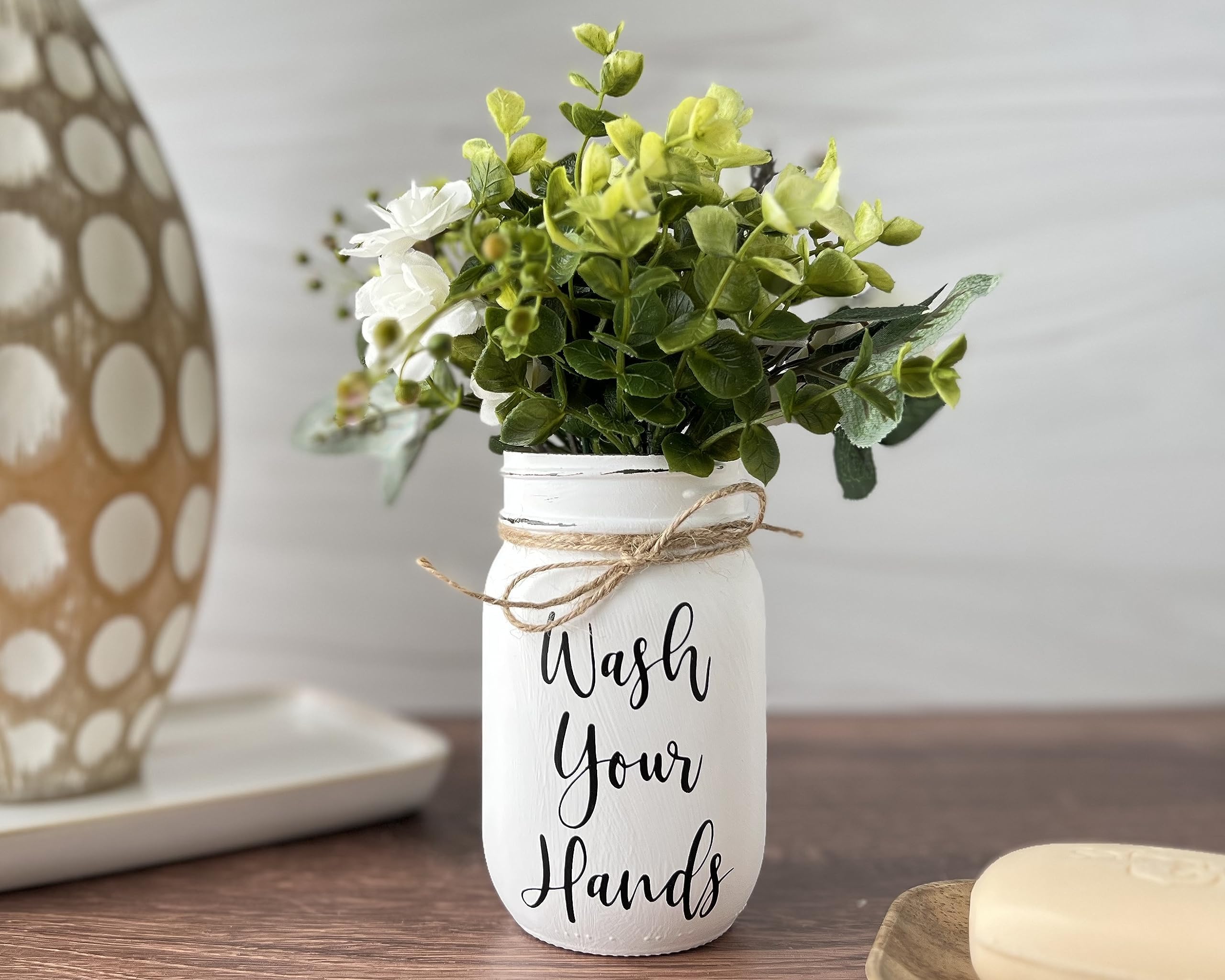 Artificial greenery and mini rose blossoms in mason jar