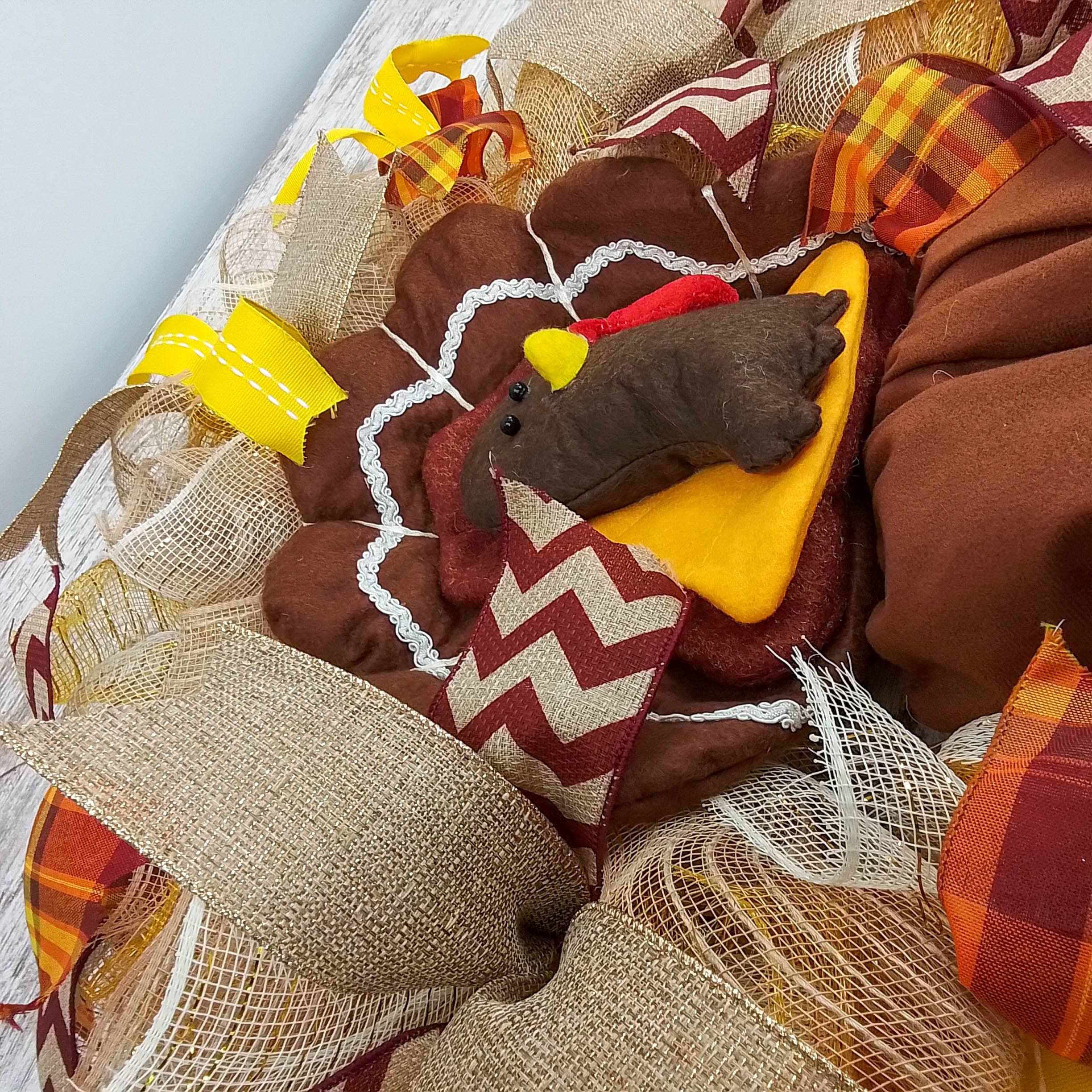 Wreath displaying mesh tail and coordinating ribbons around turkey