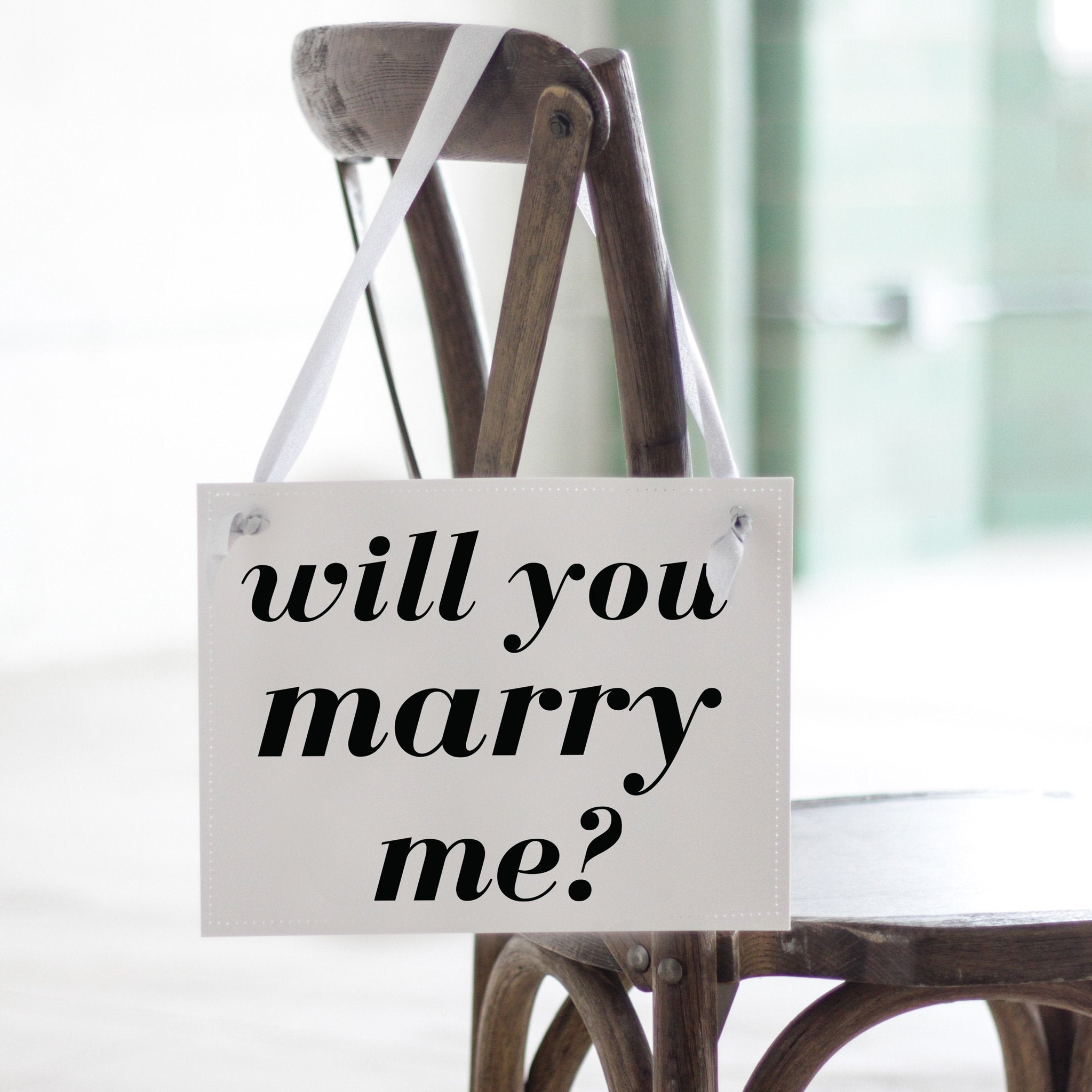 Soft gray satin ribbon wrapped around ivory sign for proposal