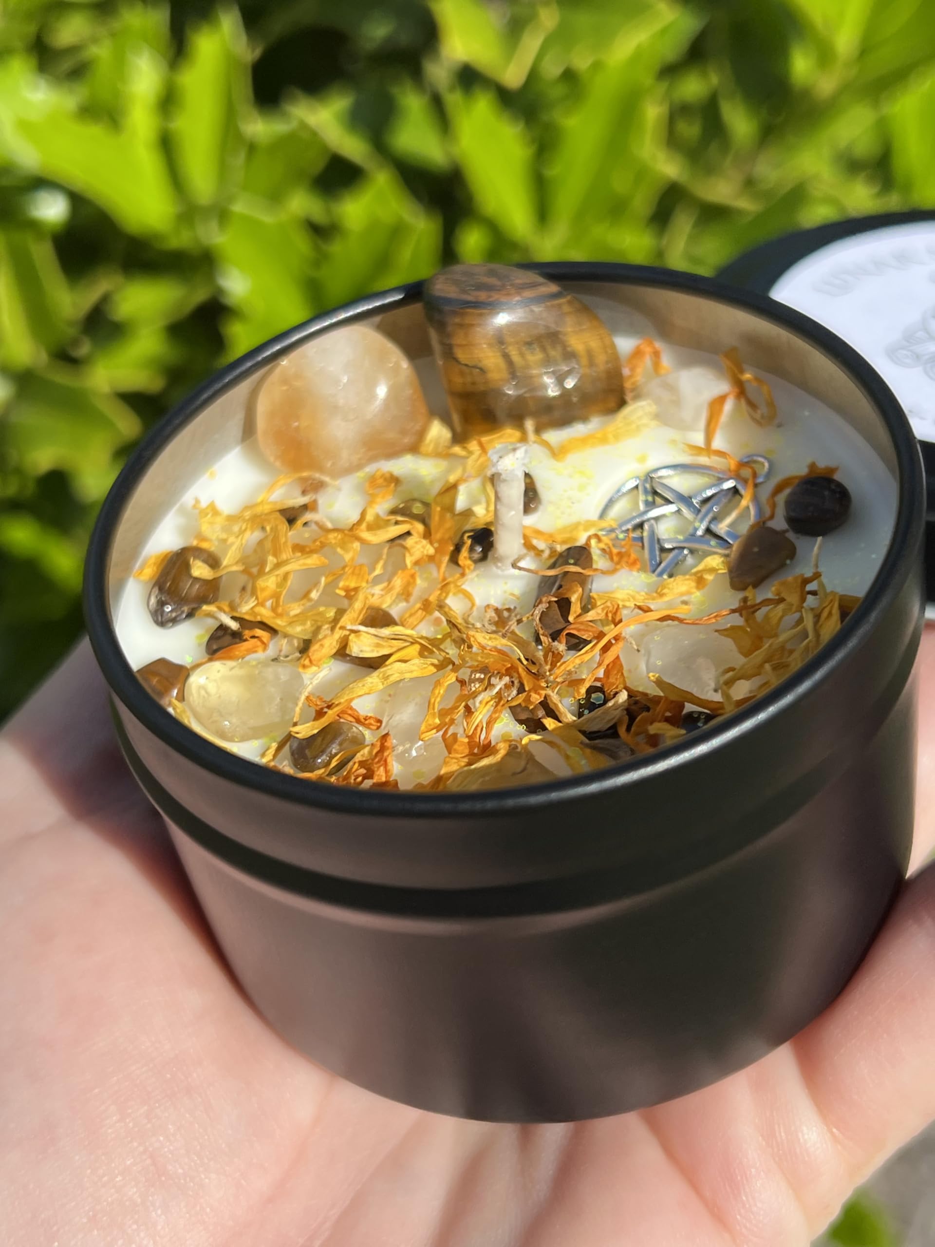 Decorative crystals, charm, and calendula accent on candle