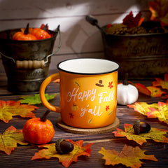 Close-up of Happy Fall Y'all text on mug with autumn leaves