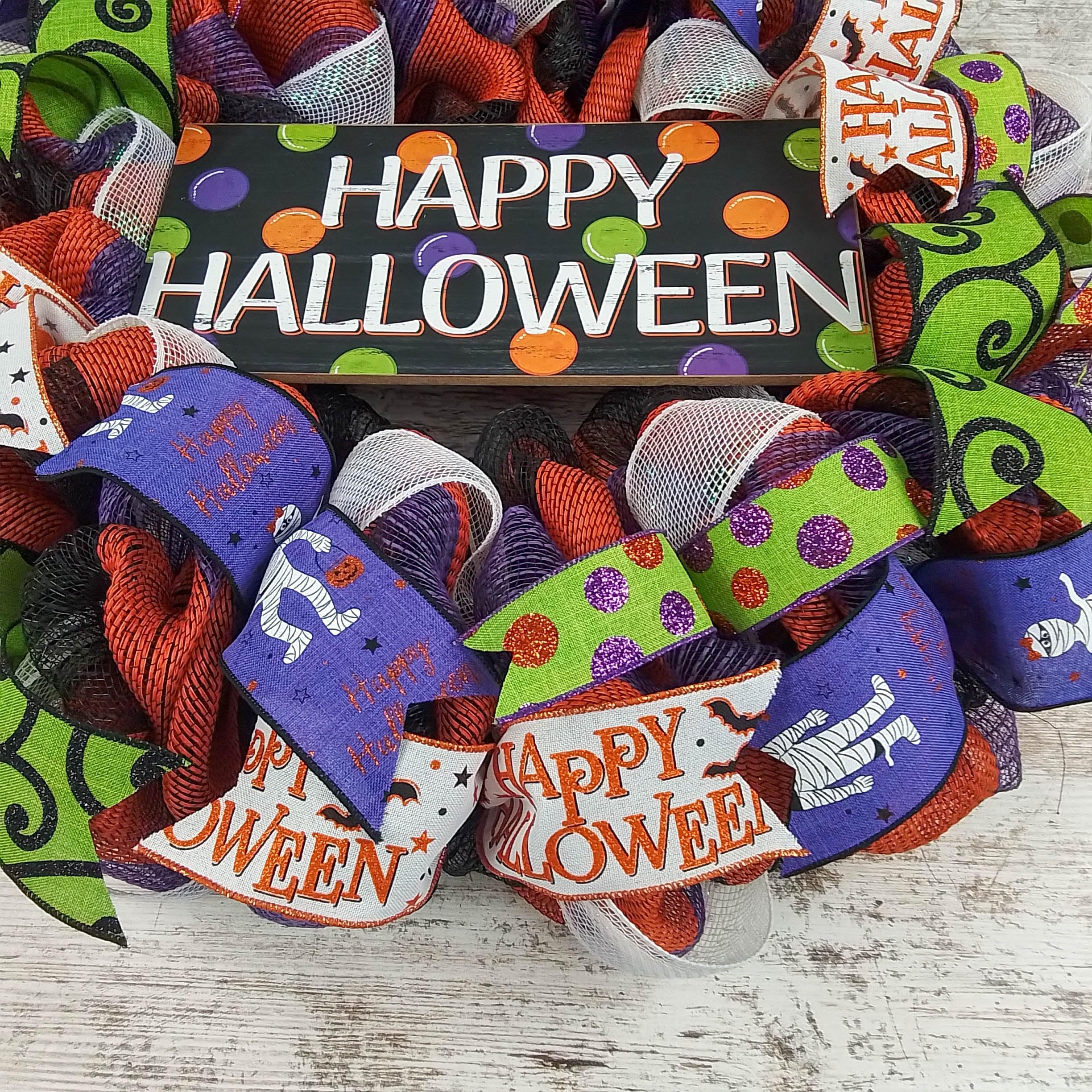 Wreath with coordinating ribbons and decorative center sign