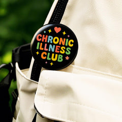 Invisible Illness Awareness pin on black circular base
