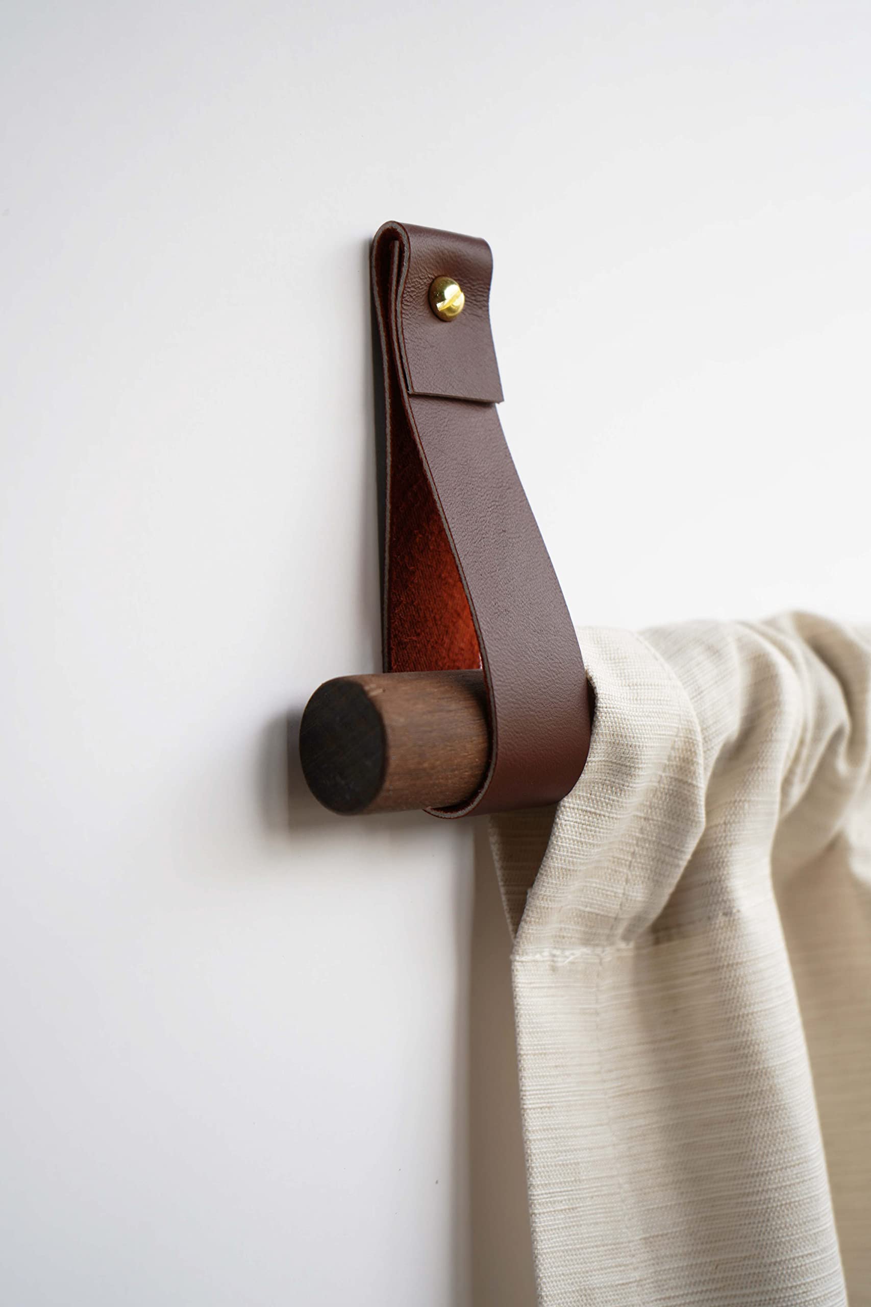 Closeup of handmade leather curtain rod holder by Keyaiira
