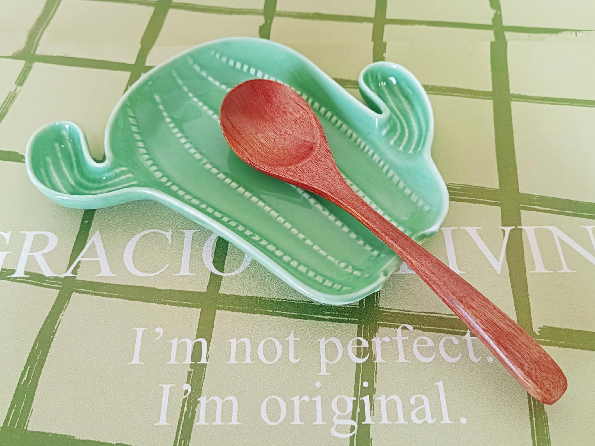Ladle rest and utensil rest on green ceramic spoon rest