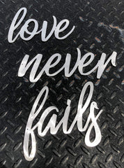 Three word panels display for Love Never Fails metal wall art accents