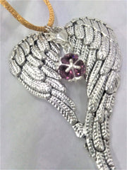Antiqued metal angel wings memorial ornament on display
