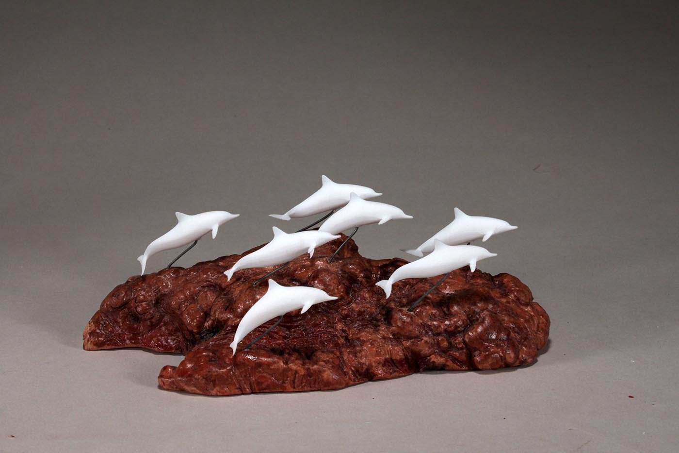 Coastal decor sculpture of dolphins on burl base