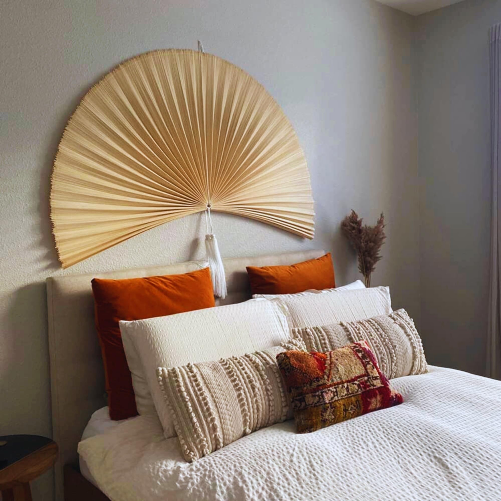 Over bed wall decor featuring a large folding fan