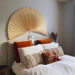 Over bed wall decor featuring a large folding fan