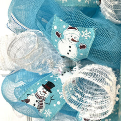 Pale blue deco mesh wreath with white snow flutes